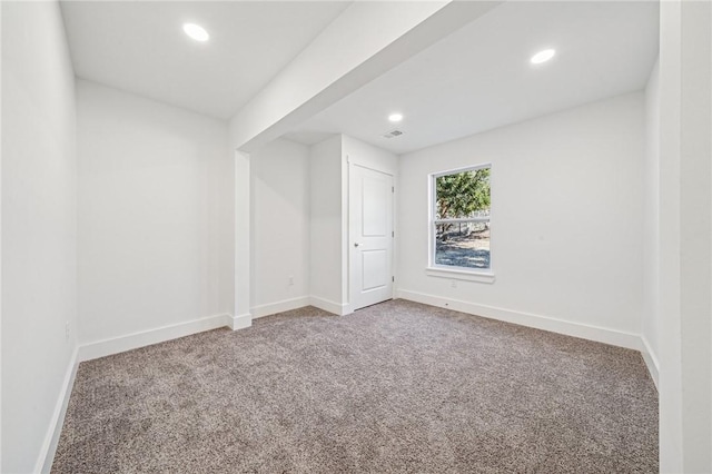 carpeted empty room featuring recessed lighting, visible vents, and baseboards