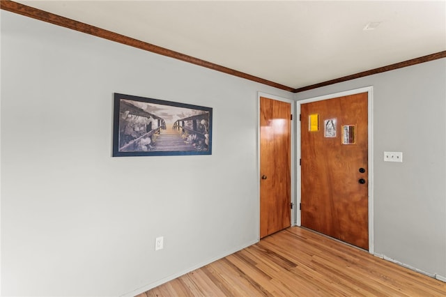 entryway featuring ornamental molding and light wood-style flooring