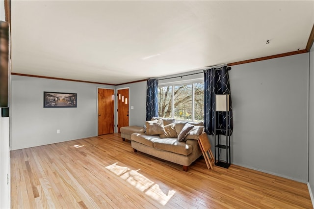 living room with ornamental molding and light wood finished floors