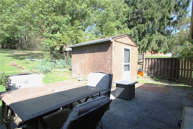 view of patio / terrace with outdoor dining space, fence, and an outbuilding