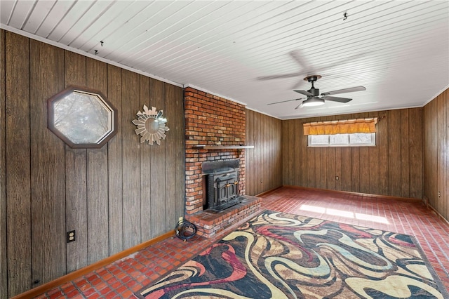 living area with wooden walls, baseboards, and a ceiling fan