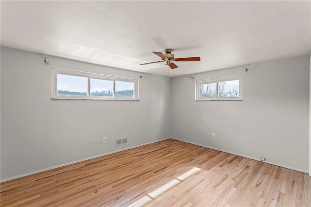 unfurnished room featuring light wood-type flooring, ceiling fan, visible vents, and baseboards