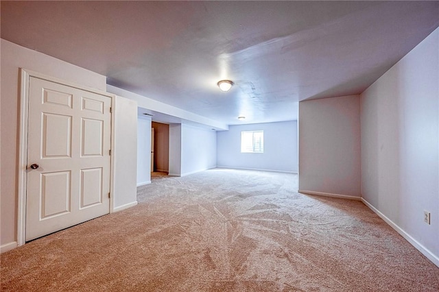 unfurnished room with light carpet and baseboards