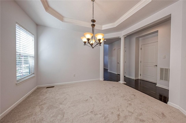 unfurnished room featuring a chandelier, a raised ceiling, visible vents, and decorative columns