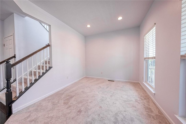 spare room with light carpet, baseboards, visible vents, stairs, and recessed lighting