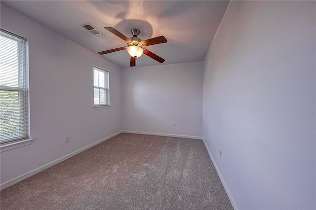 spare room with baseboards, visible vents, ceiling fan, and carpet flooring