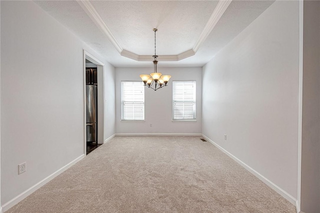 unfurnished room featuring carpet floors, a tray ceiling, ornamental molding, a textured ceiling, and baseboards