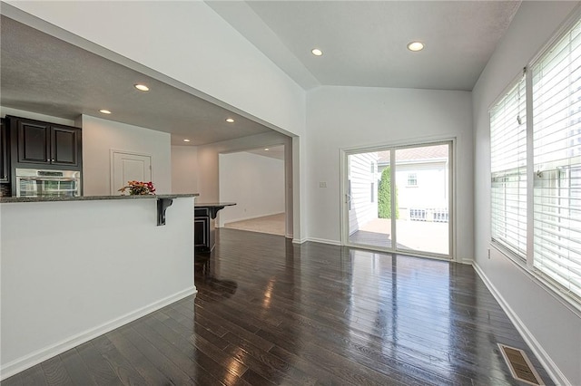 living room with baseboards, visible vents, dark wood-type flooring, vaulted ceiling, and recessed lighting