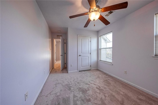 unfurnished bedroom with light carpet, ceiling fan, visible vents, and baseboards