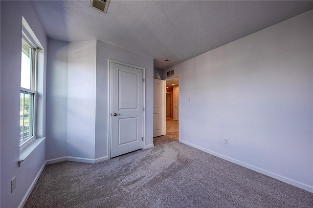 unfurnished bedroom with baseboards, visible vents, and carpet flooring