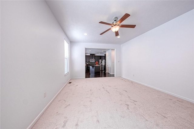 empty room featuring ceiling fan, recessed lighting, dark carpet, and baseboards