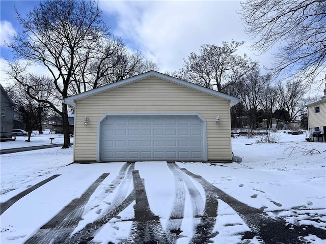 snow covered garage featuring a garage