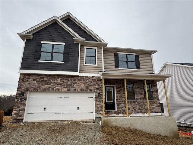 view of front of house with an attached garage, driveway, a porch, and stone siding