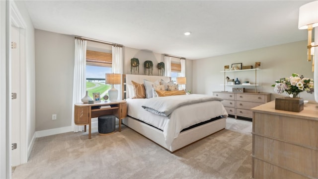 bedroom featuring light carpet and baseboards