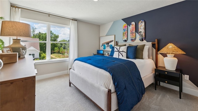 bedroom featuring baseboards, a textured ceiling, and light colored carpet