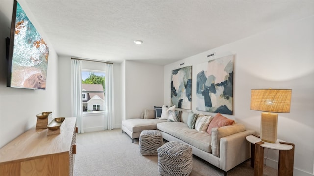 living area with light carpet, visible vents, and a textured ceiling