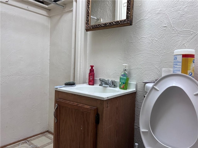 bathroom with a textured wall, vanity, and tile patterned floors