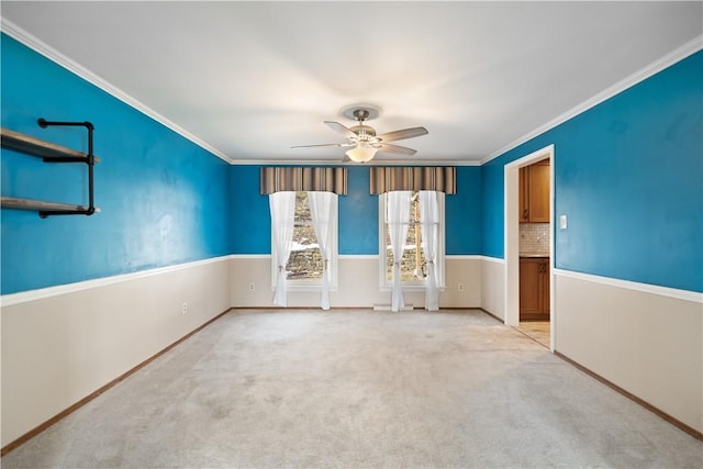 unfurnished room with light carpet, baseboards, a ceiling fan, and crown molding