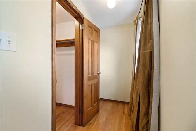 hall featuring baseboards and light wood-style floors