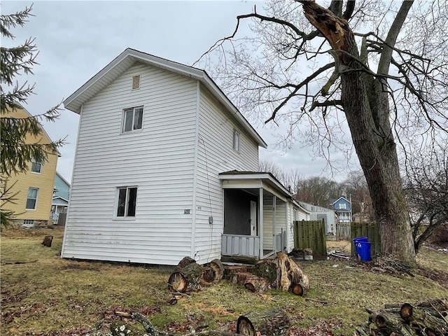 rear view of property with entry steps and fence