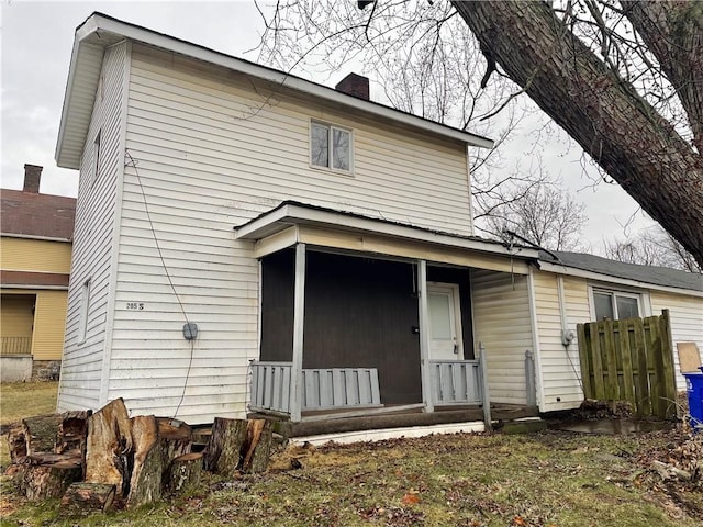 back of house featuring a chimney