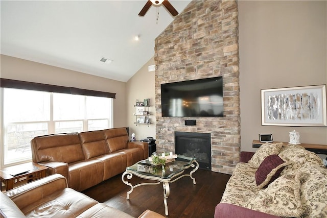 living area featuring a large fireplace, visible vents, a ceiling fan, dark wood-style flooring, and high vaulted ceiling