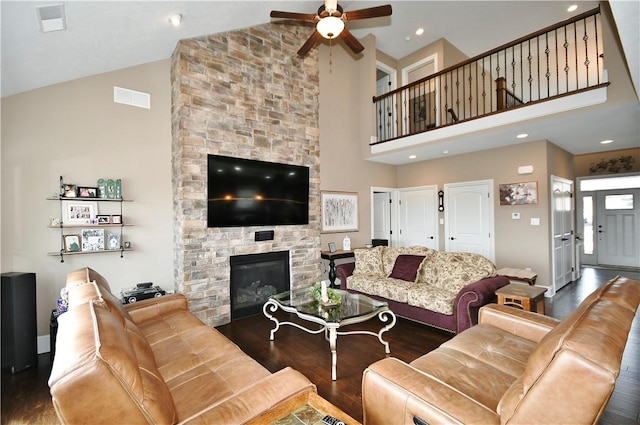 living room with high vaulted ceiling, dark wood-style flooring, visible vents, and a fireplace