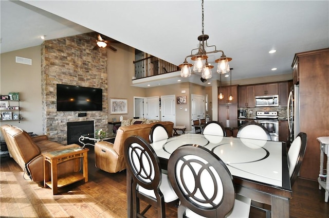 dining space with a fireplace, recessed lighting, visible vents, an inviting chandelier, and wood finished floors