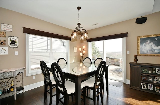 dining room featuring a notable chandelier, dark wood-style flooring, visible vents, and baseboards