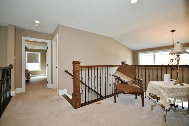 sitting room with lofted ceiling, carpet floors, an upstairs landing, and a healthy amount of sunlight