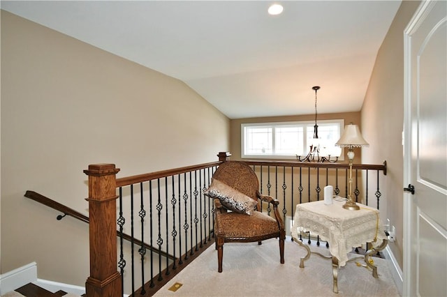 sitting room with a chandelier, lofted ceiling, baseboards, and an upstairs landing