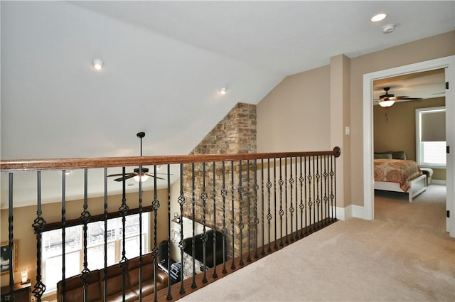 hallway with lofted ceiling, baseboards, and carpet flooring