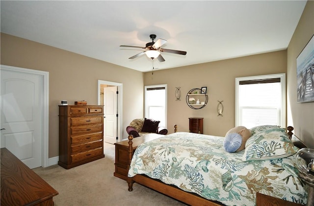 bedroom with light colored carpet, multiple windows, ceiling fan, and baseboards