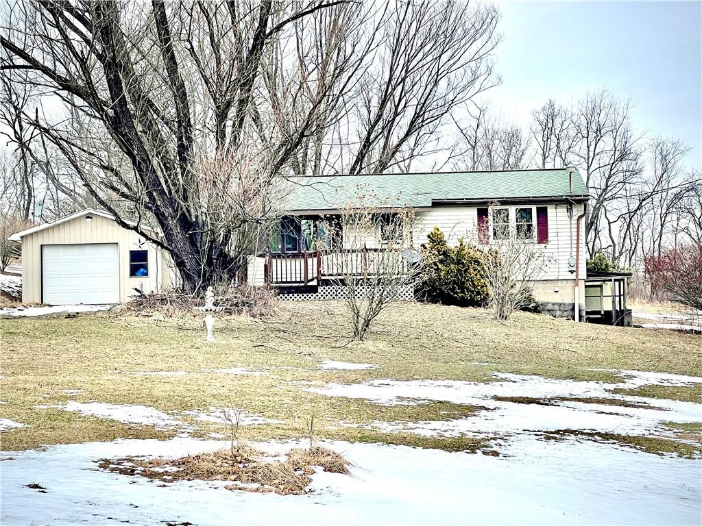 view of front of property with a garage, an outbuilding, and a yard