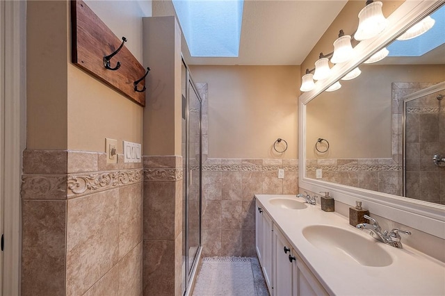 full bathroom with a skylight, a shower stall, tile walls, and a sink