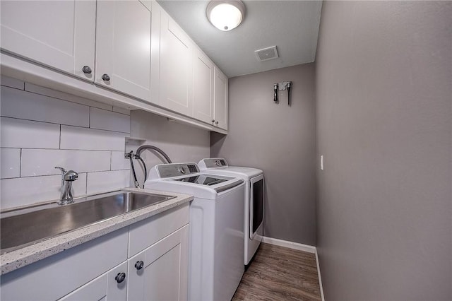 laundry area with a sink, visible vents, baseboards, cabinet space, and washer and clothes dryer