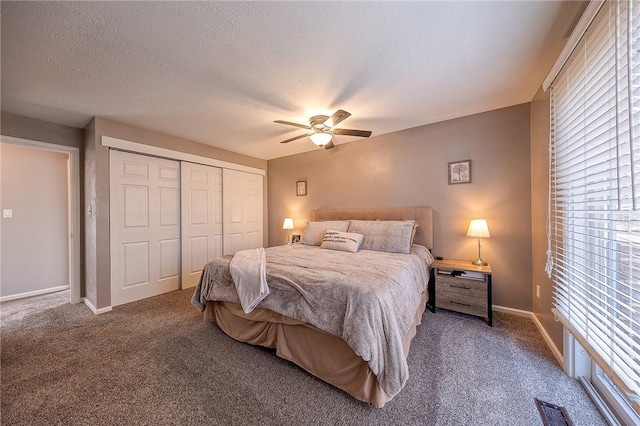 carpeted bedroom with a textured ceiling, a ceiling fan, visible vents, baseboards, and a closet