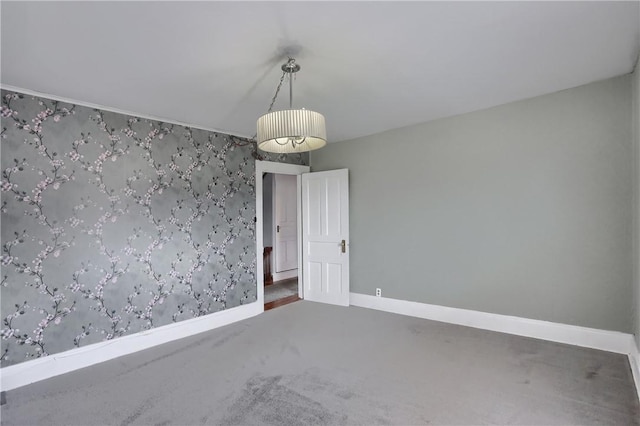 unfurnished room with carpet floors and baseboards