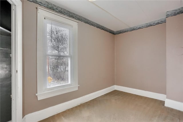 carpeted empty room featuring a healthy amount of sunlight and baseboards