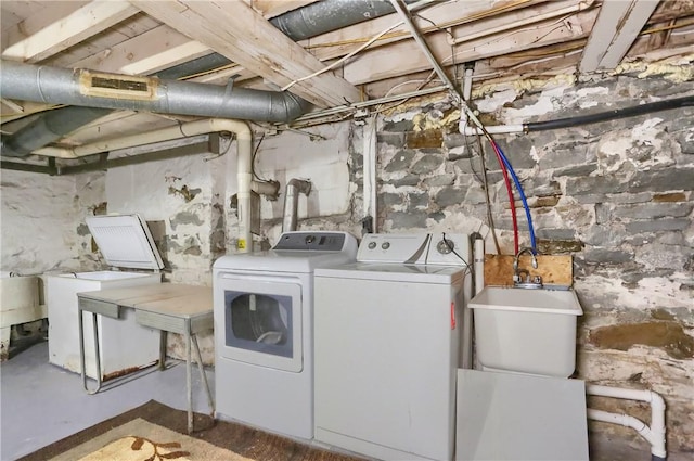 laundry area with laundry area, a sink, and washing machine and clothes dryer