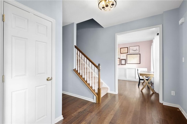 interior space featuring dark wood-type flooring, stairway, and baseboards