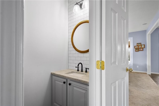 bathroom with baseboards, backsplash, and vanity