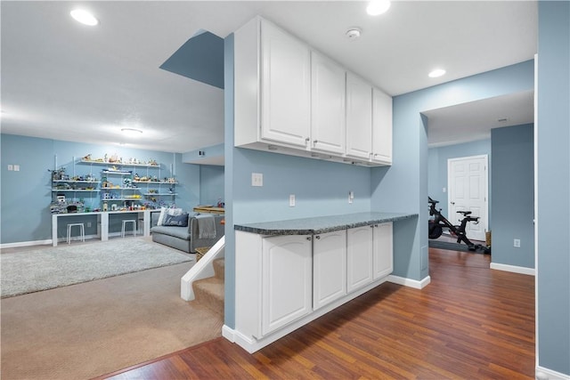 kitchen with dark wood finished floors, recessed lighting, dark colored carpet, white cabinetry, and baseboards