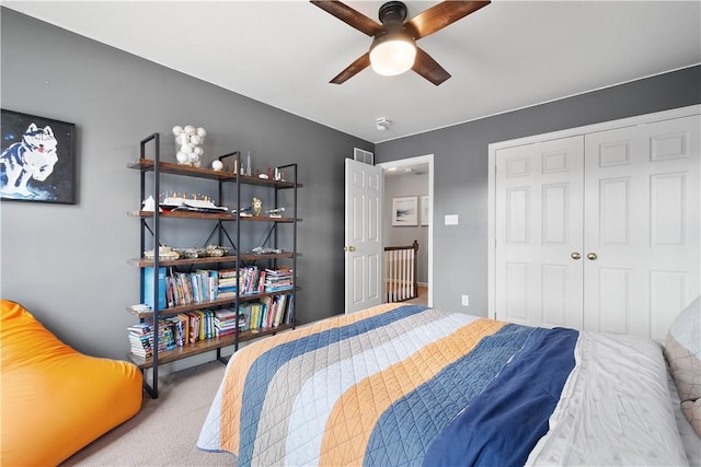 bedroom with a ceiling fan, a closet, and light carpet