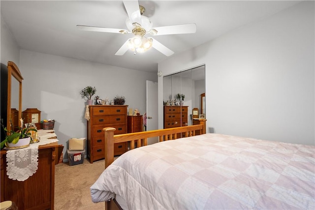 bedroom with a ceiling fan, a closet, and light colored carpet