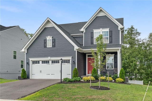 view of front of house with a garage, a front yard, and driveway