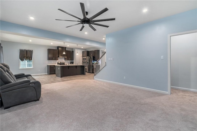 living room featuring recessed lighting, light colored carpet, baseboards, and stairs