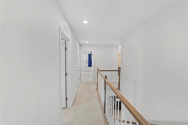 corridor featuring visible vents, baseboards, light colored carpet, an upstairs landing, and recessed lighting