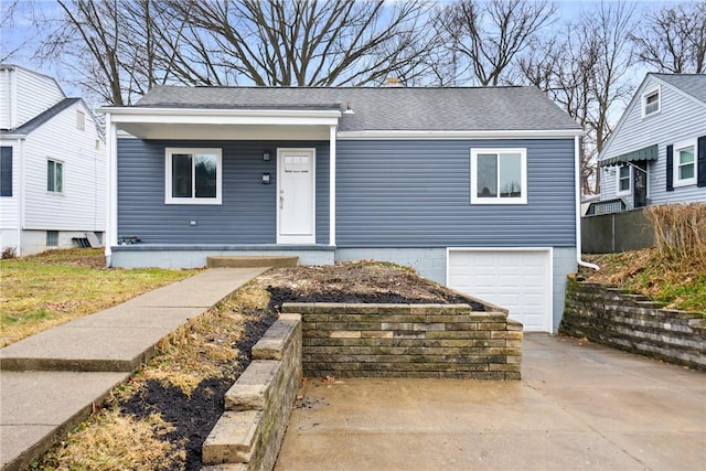 bungalow-style house featuring a garage, concrete driveway, and roof with shingles