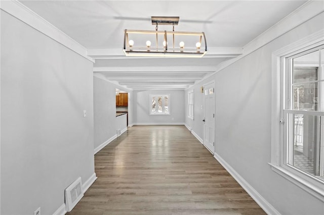 interior space featuring baseboards, visible vents, a chandelier, and wood finished floors